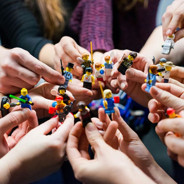 Children holding Lego minifigures together